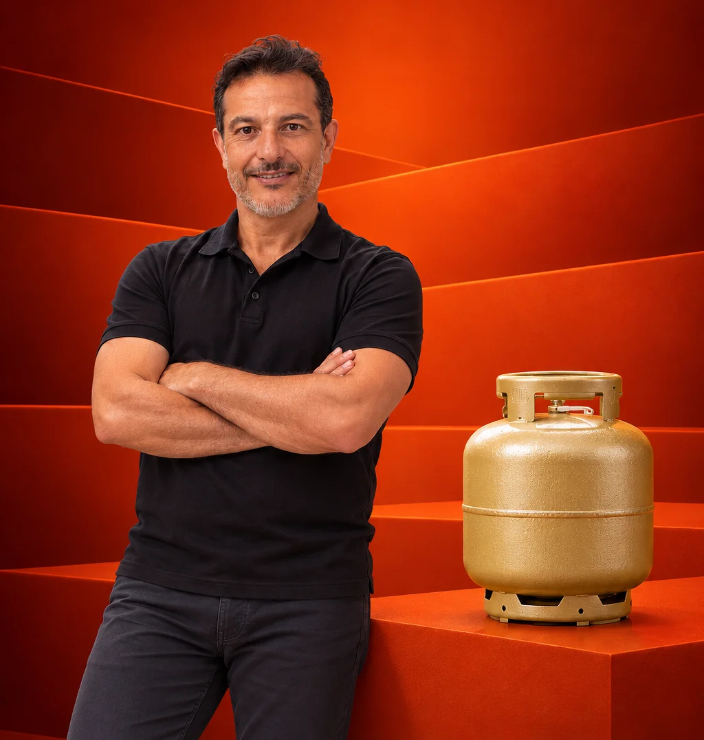 Miltão sorridente de braços cruzados ao lado do botijão de gás P13 dourado Supergasbras